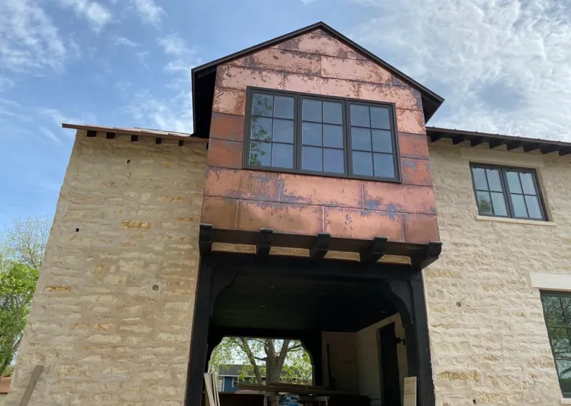 Copper metal panel facade on a stone building for Skylight Installation in Eau Claire