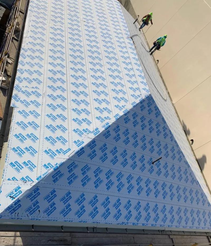 Professional roofers installing underlayment on a metal roof in Eau Claire